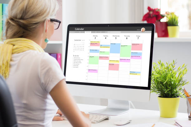 Woman checking her work calendar on desktop (time management strategies blog)