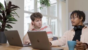 2 people sitting with laptops generative ai for hr