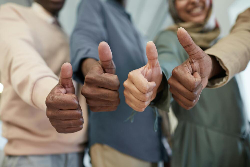 four people giving thumbs-up for JD approval | Ongig Blog four people giving thumbs-up for JD approval