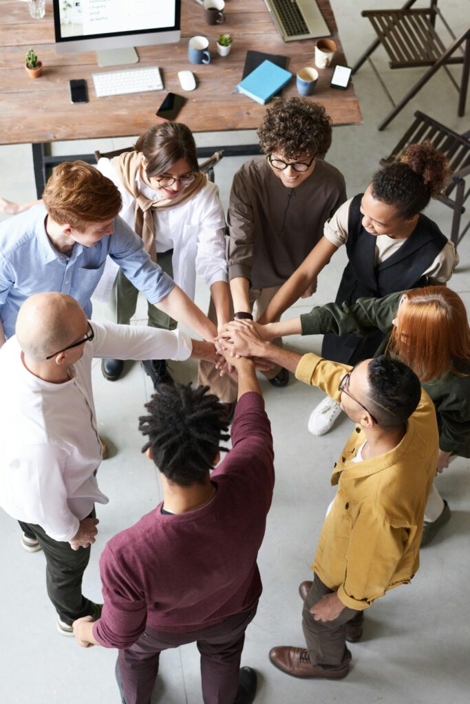pexels-fauxels-3184423 | Ongig Blog A diverse community of employees engaged in a team huddle.